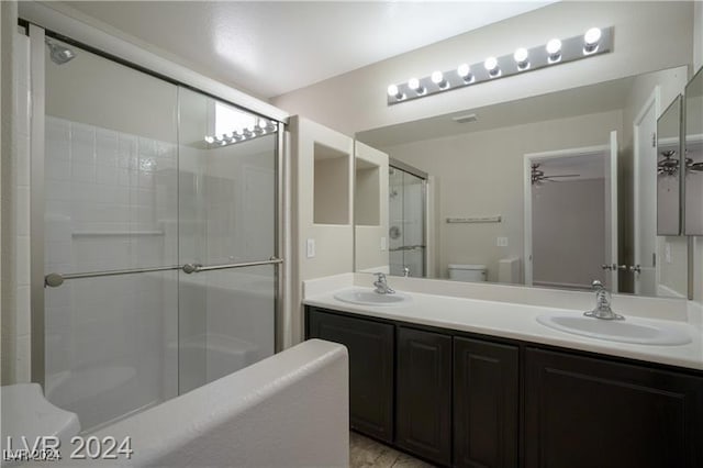 bathroom featuring walk in shower, ceiling fan, vanity, and toilet