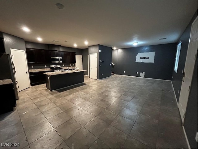 kitchen with an island with sink and stainless steel appliances