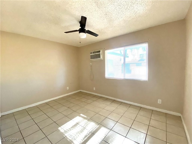 unfurnished room with ceiling fan, an AC wall unit, a textured ceiling, and light tile patterned floors