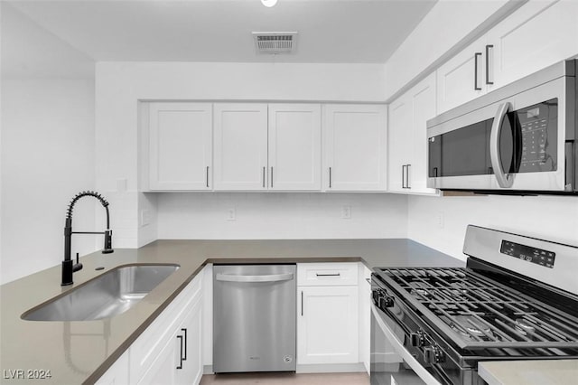 kitchen featuring backsplash, sink, white cabinets, and appliances with stainless steel finishes