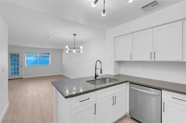 kitchen with kitchen peninsula, sink, pendant lighting, dishwasher, and white cabinetry