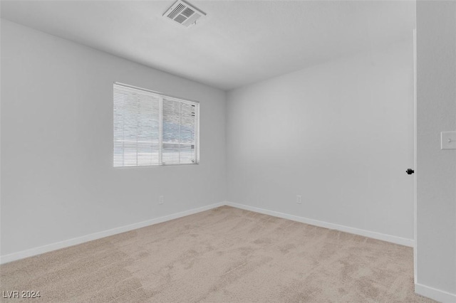 spare room featuring light colored carpet