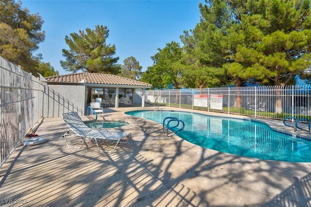 view of pool with a patio area and a community hot tub