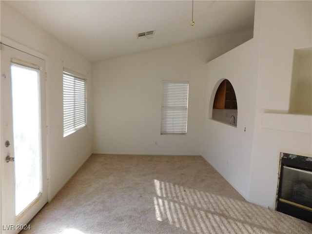 unfurnished living room with a premium fireplace and light carpet