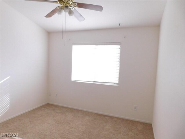 carpeted spare room featuring ceiling fan and plenty of natural light