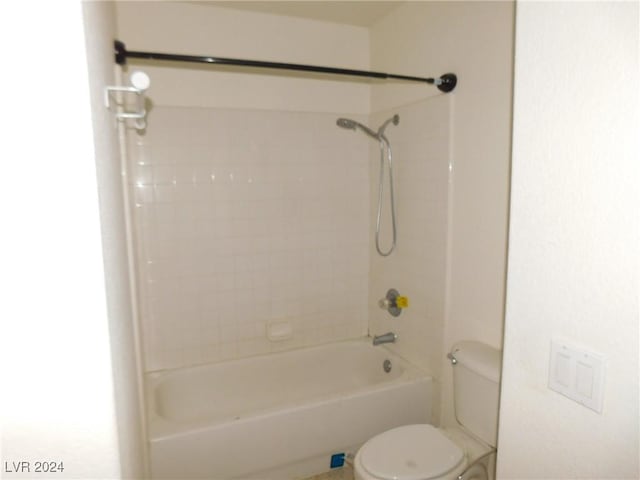 bathroom featuring tiled shower / bath combo and toilet