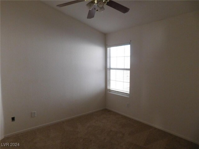 unfurnished room with ceiling fan, dark carpet, and vaulted ceiling