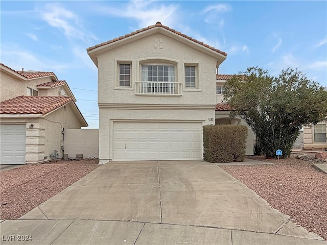 view of front of house featuring driveway, a tile roof, a garage, and stucco siding