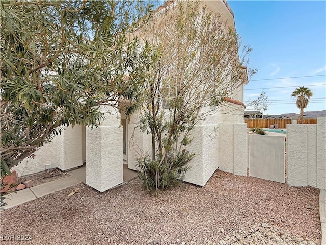 view of side of property with fence and stucco siding