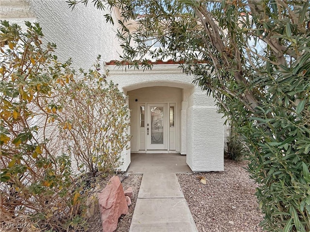 entrance to property featuring stucco siding