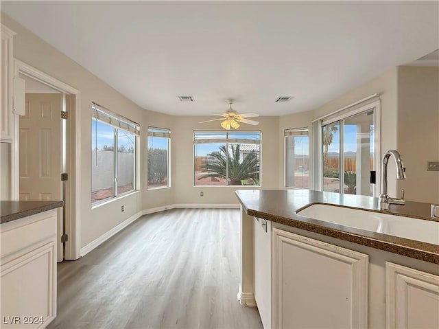 kitchen featuring dark countertops, visible vents, and a sink