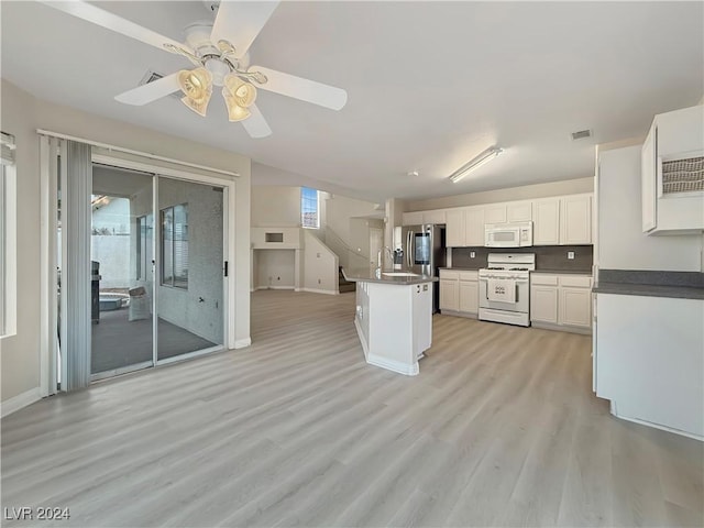 kitchen with light wood-style flooring, white appliances, visible vents, white cabinetry, and dark countertops