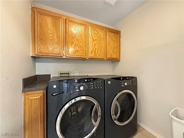 clothes washing area featuring washing machine and dryer, cabinet space, baseboards, and light tile patterned floors