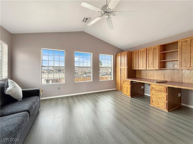 home office with vaulted ceiling, wood finished floors, built in study area, and a wealth of natural light