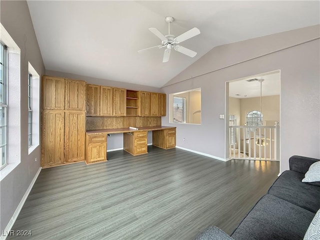 office space with baseboards, a ceiling fan, dark wood-style flooring, vaulted ceiling, and built in desk