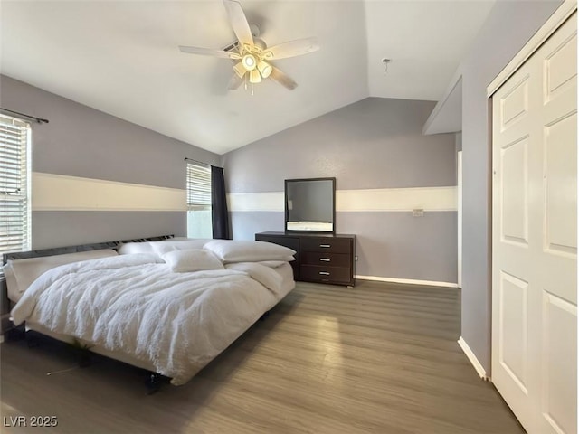 bedroom featuring lofted ceiling, wood finished floors, a ceiling fan, and baseboards