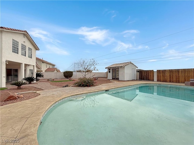 view of pool featuring an outbuilding, a fenced backyard, and a fenced in pool