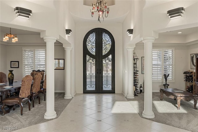 foyer entrance with a wealth of natural light, french doors, and a chandelier