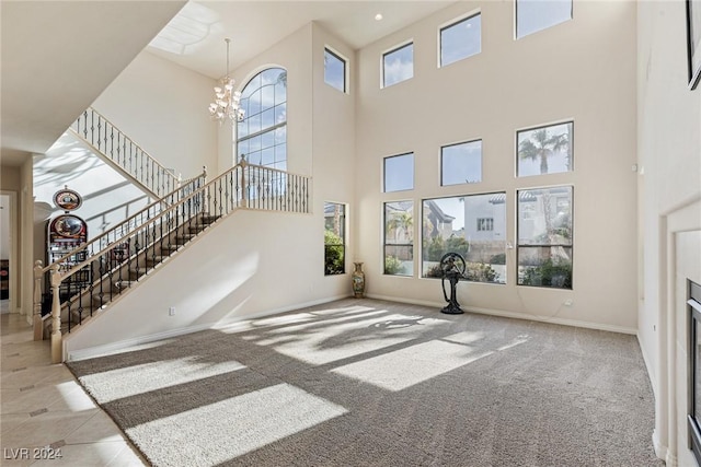 living room featuring light carpet, a towering ceiling, and an inviting chandelier