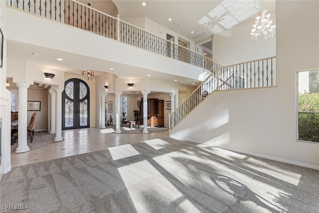 carpeted living room featuring french doors, a chandelier, and a high ceiling