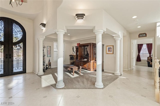 entrance foyer featuring french doors, light tile patterned flooring, and an inviting chandelier