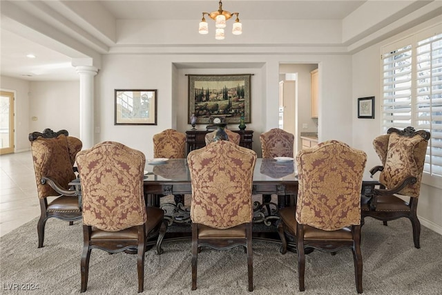 dining space featuring tile patterned flooring, decorative columns, and an inviting chandelier