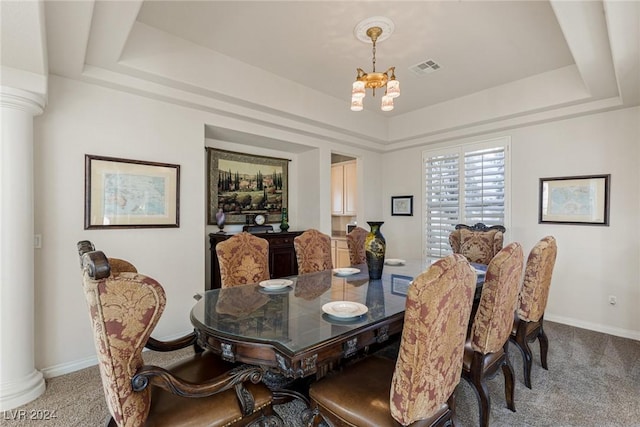 carpeted dining area with an inviting chandelier, decorative columns, and a tray ceiling