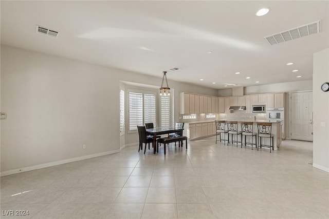 tiled dining space with a chandelier