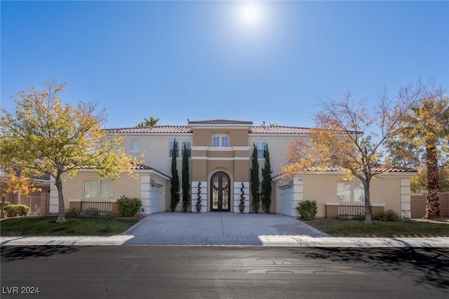 mediterranean / spanish-style home with a garage, a balcony, and french doors