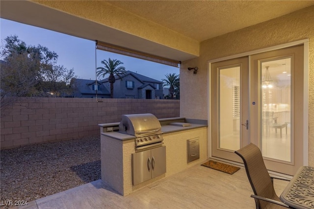 patio terrace at dusk featuring area for grilling and grilling area