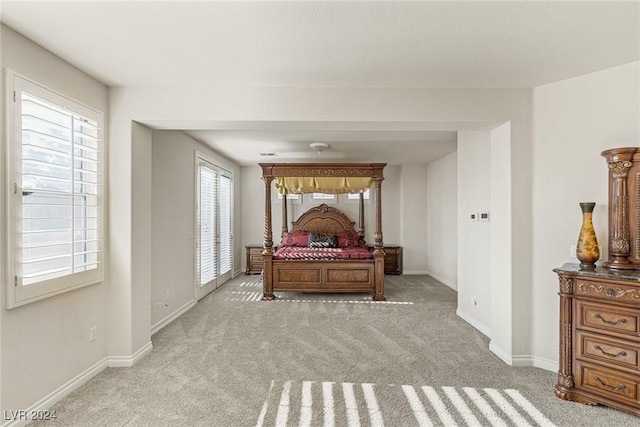 bedroom with light carpet and multiple windows