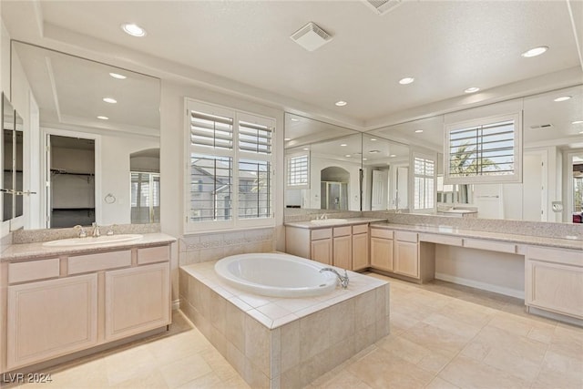 bathroom with vanity, tile patterned floors, and tiled tub