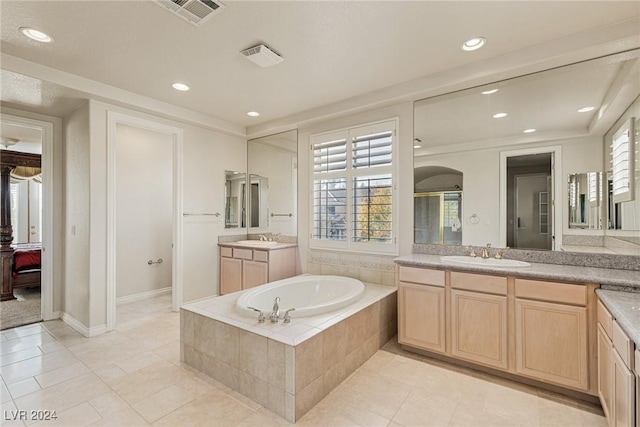 bathroom with tile patterned floors, a wealth of natural light, and vanity