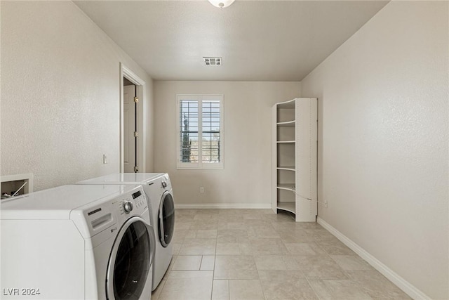 clothes washing area featuring washer and dryer and light tile patterned floors