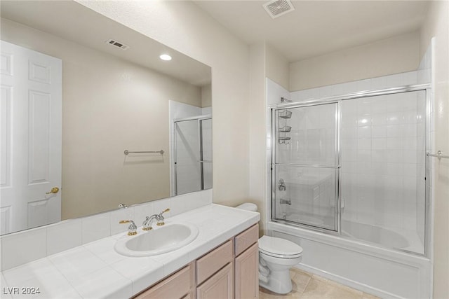 full bathroom with tile patterned flooring, vanity, toilet, and combined bath / shower with glass door