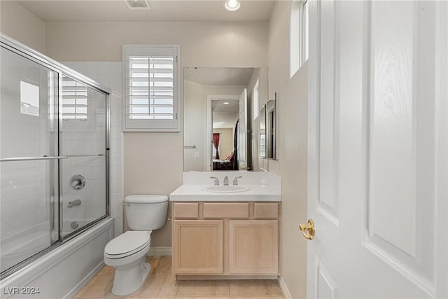 full bathroom with tile patterned floors, toilet, combined bath / shower with glass door, and vanity