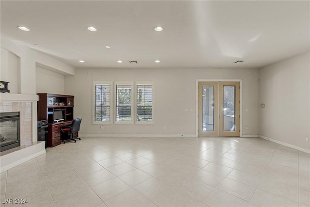 tiled living room with a fireplace and french doors