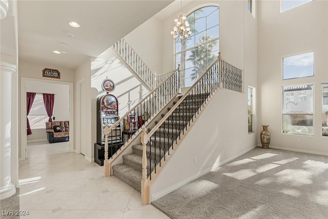 stairs featuring carpet flooring, a towering ceiling, and an inviting chandelier