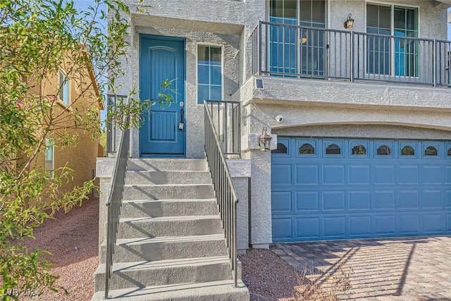 entrance to property with a garage and a balcony