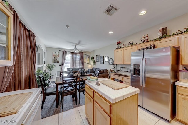 kitchen featuring ceiling fan, light brown cabinets, stainless steel refrigerator with ice dispenser, tile countertops, and light tile patterned floors