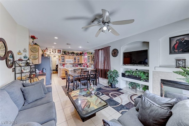 living room with ceiling fan, light tile patterned floors, and a fireplace