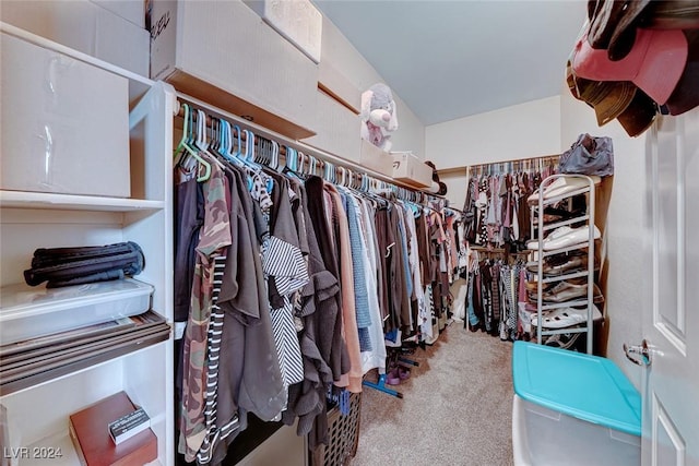 walk in closet featuring light colored carpet