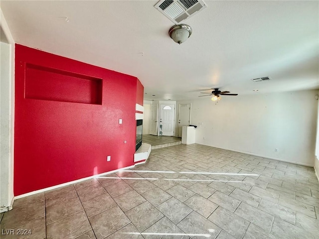 unfurnished living room featuring ceiling fan