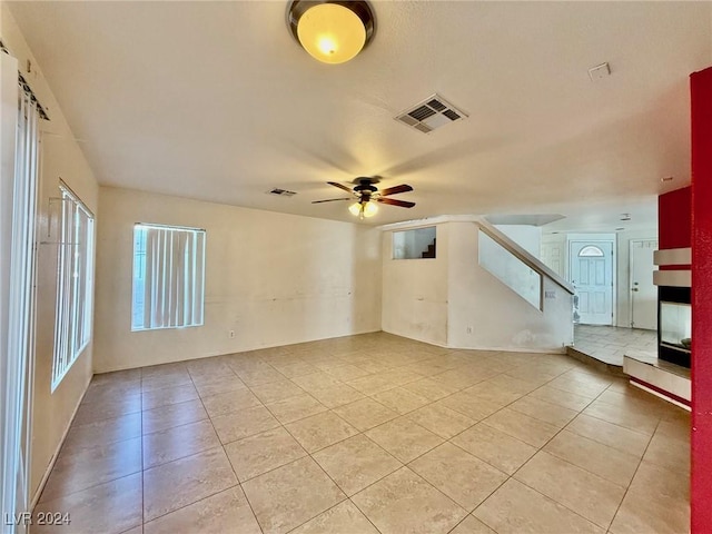 tiled empty room featuring ceiling fan