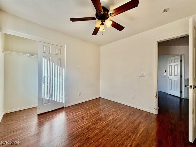 unfurnished bedroom with a closet, dark hardwood / wood-style floors, and ceiling fan