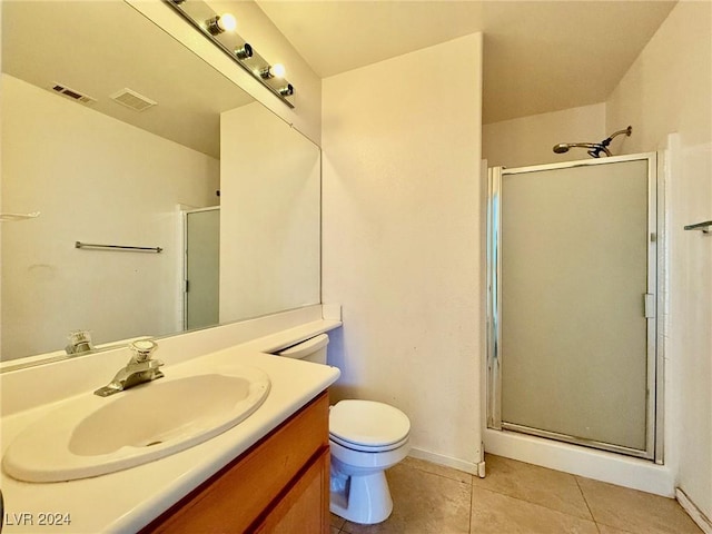 bathroom featuring tile patterned flooring, vanity, toilet, and an enclosed shower