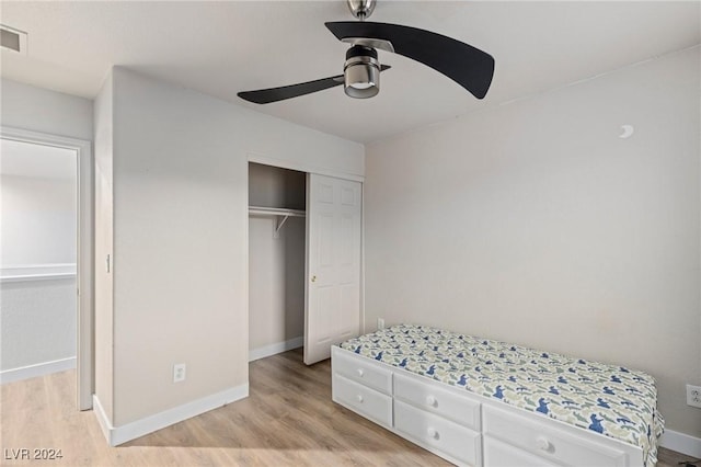 bedroom with ceiling fan, a closet, and light hardwood / wood-style floors