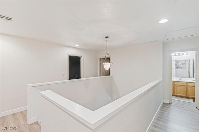 corridor featuring light hardwood / wood-style flooring and sink