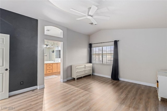 bedroom featuring ensuite bath, ceiling fan, sink, light hardwood / wood-style floors, and lofted ceiling