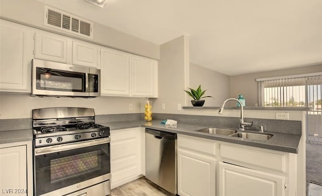 kitchen featuring white cabinets, sink, kitchen peninsula, and stainless steel appliances